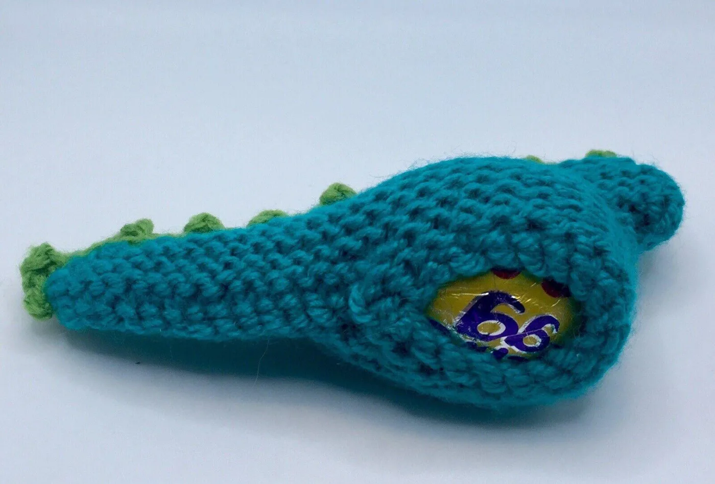 Hand knitted dinosaur creme egg cover underneath