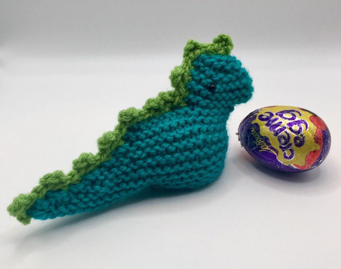 Hand knitted dinosaur creme egg cover side with egg